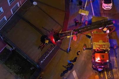 2’nci kattan kafenin tentesine düşen şahsı itfaiye aşağıya indirdi