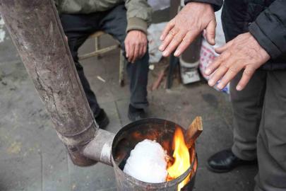 Erzincan pazarcısı soğukta sobayla ısınıyor